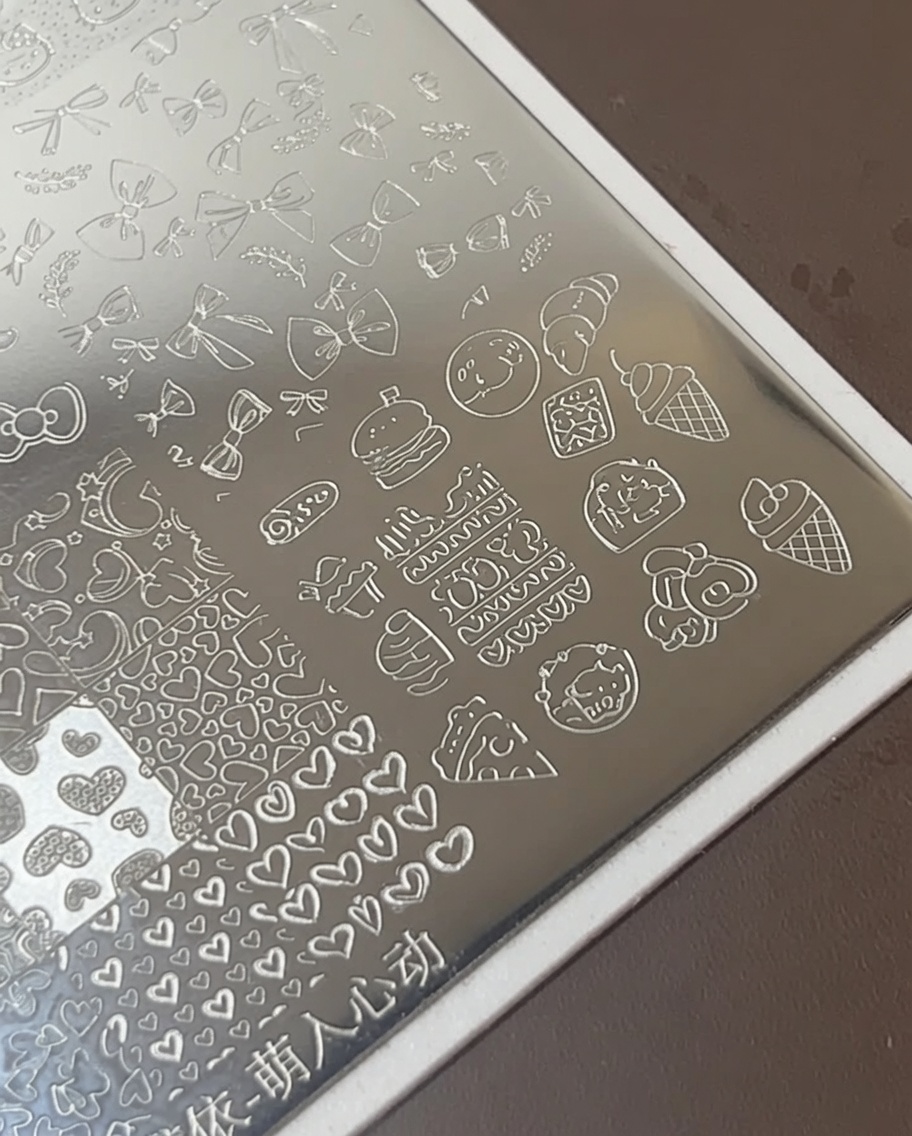 スタンププレートのフードモチーフに白いポリッシュを乗せている様子