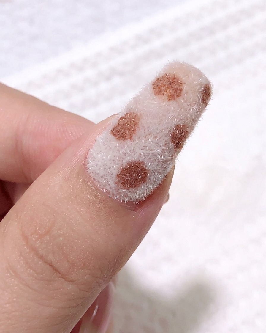 細いラインブラシを使い、質感のある表面にブラックのジェルでレオパード柄の輪郭を描いているクローズアップ画像。
