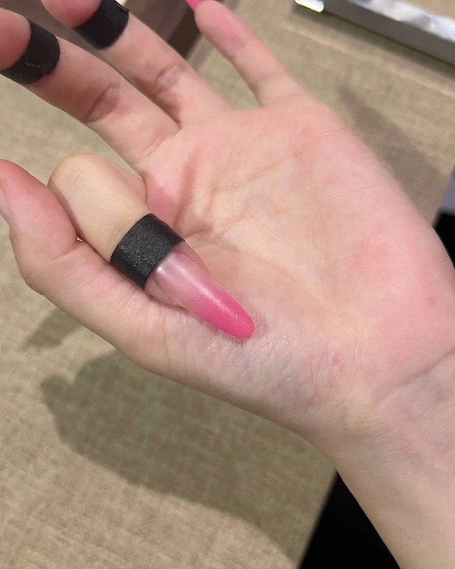 爪全体にピンクのキャッツアイジェルを塗布している様子