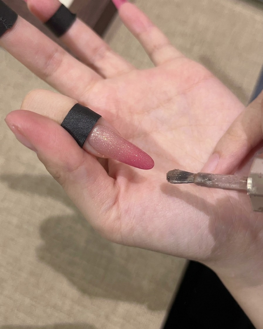 マグネットを爪と並行に持ち、輝きを引き出している様子