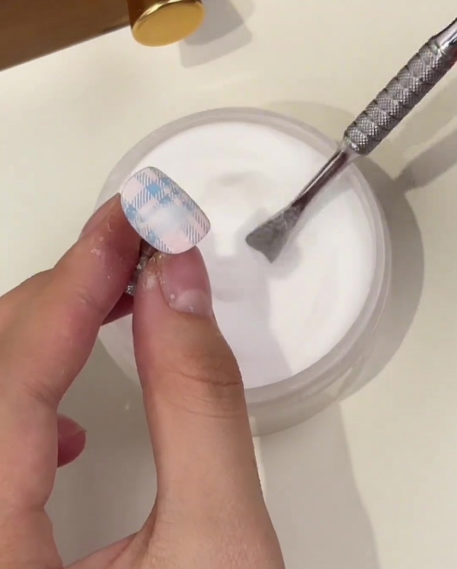 パウダー容器の上でチェック柄にパウダーをたっぷり振りかけている様子