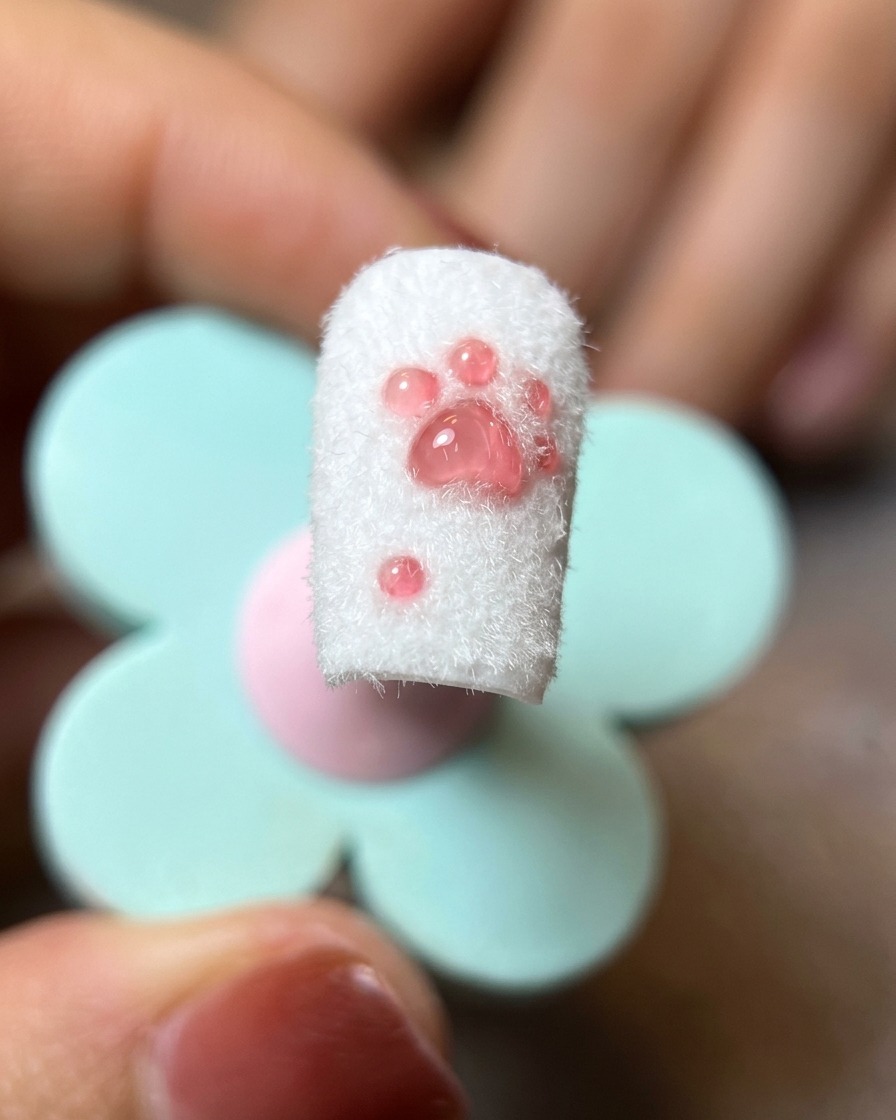 柔らかいネイルブラシで、完成したネイルから余分なパウダーを払い落としている様子。