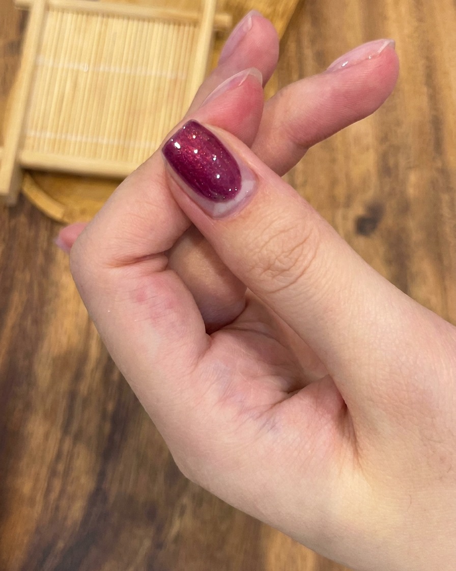 鮮やかなローズレッドのマグネットジェルを爪全体に均一に塗るプロ用ネイルブラシ。