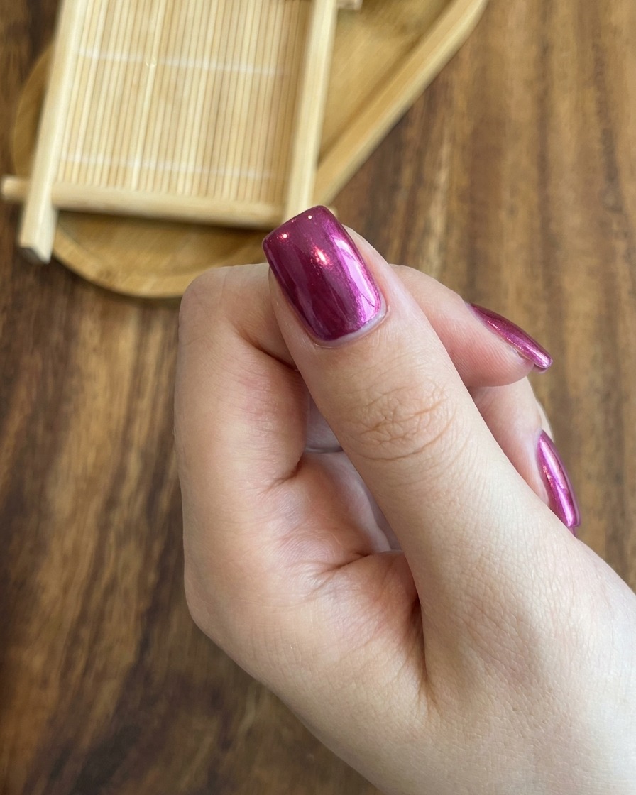 マグネットを使って、ローズレッドの爪に鮮やかなキャッツアイのラインを正確に中央に合わせている様子。