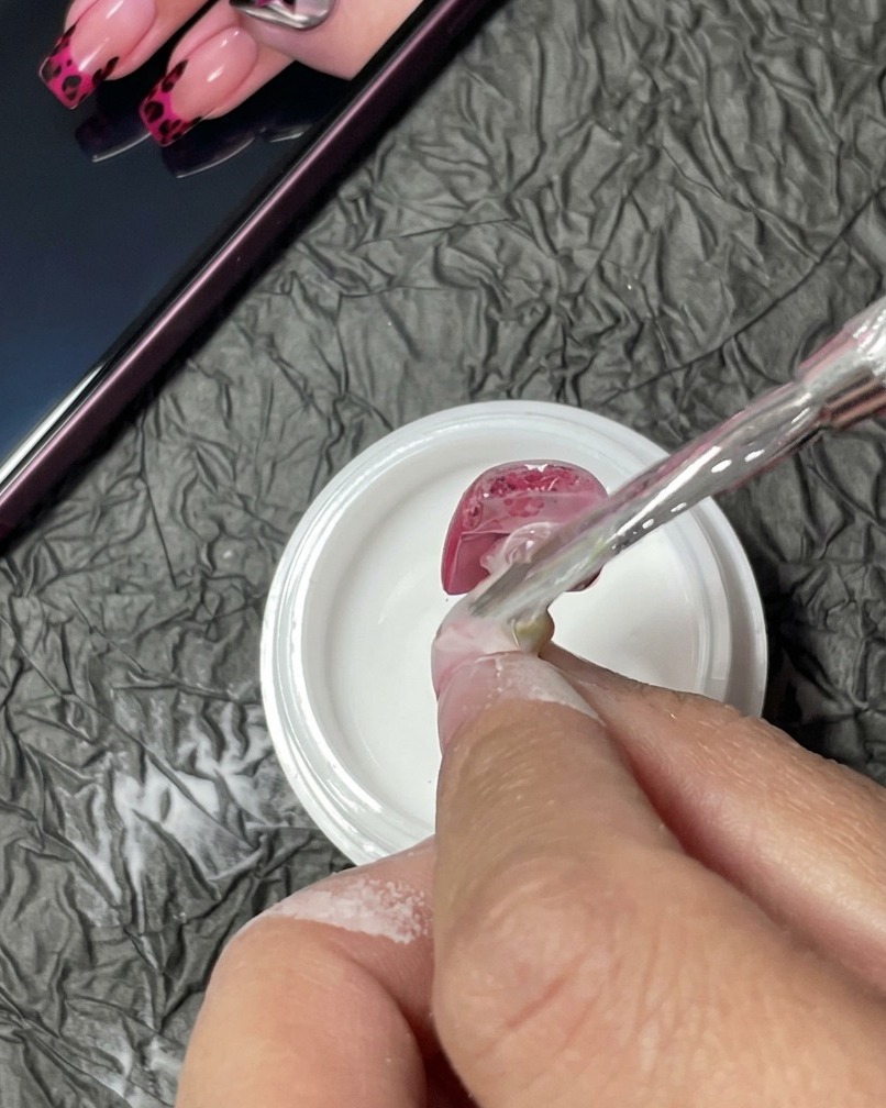 UV/LEDランプの中で、最終的な硬化工程にあるネイルチップ。