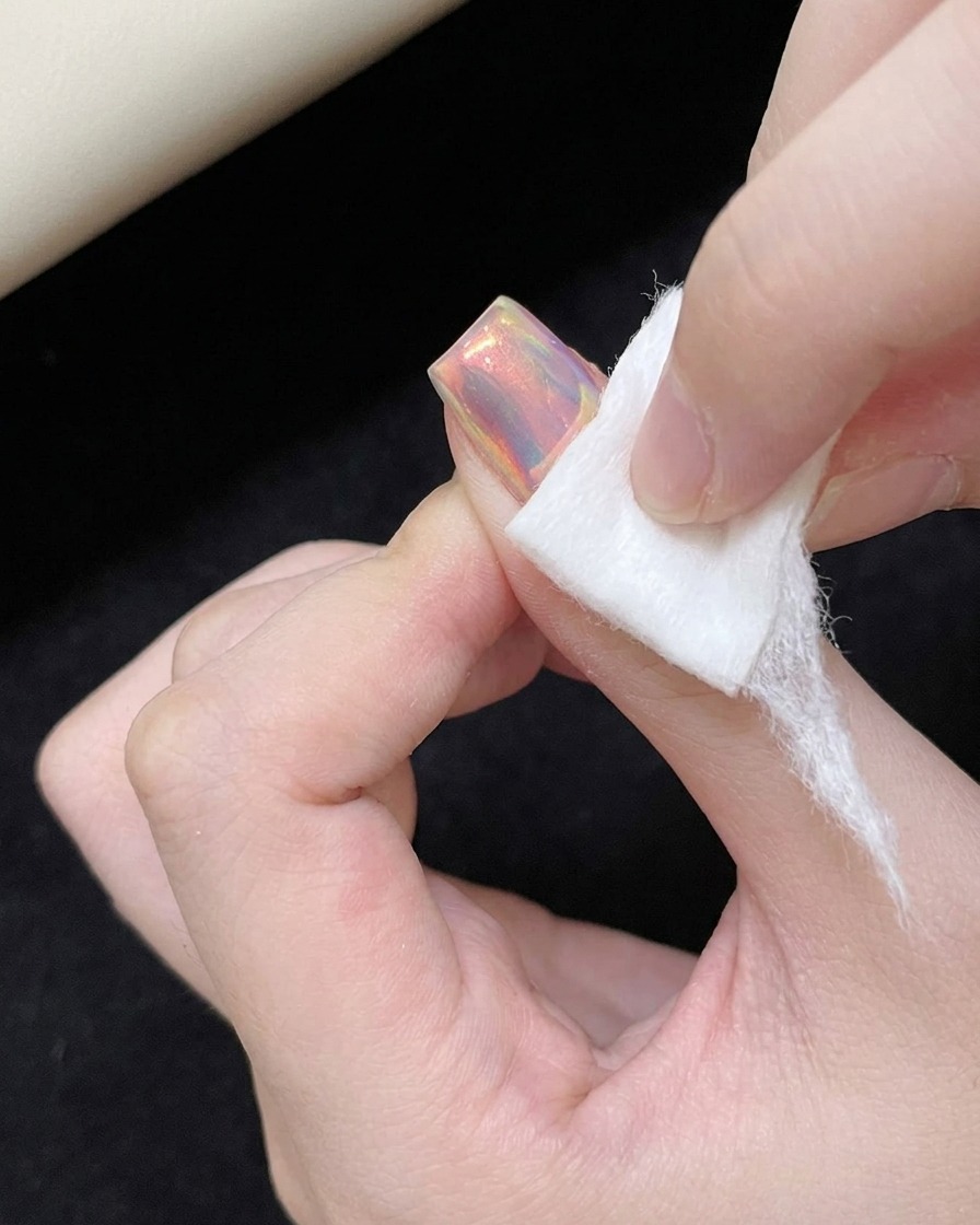 チップを使ってオーロラパウダーをネイル表面にこすりつけている様子。