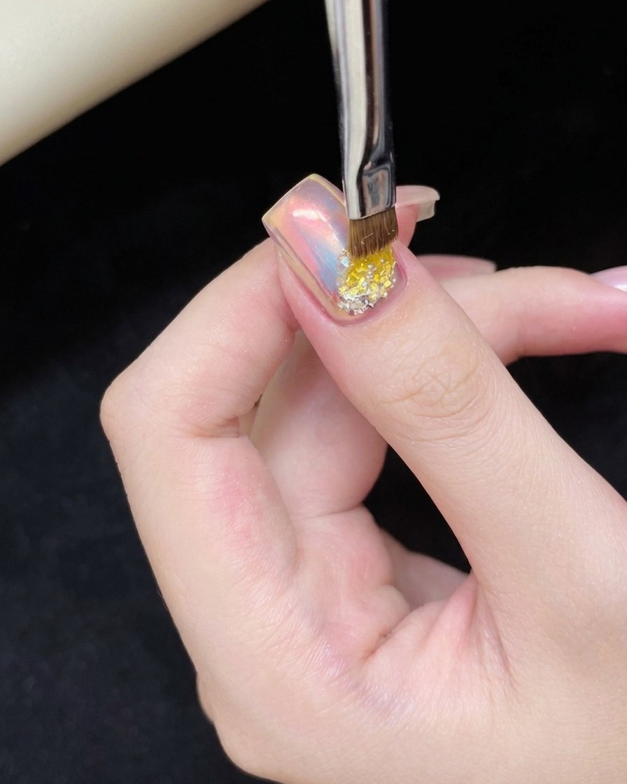 ベース部分にクリアジェルを塗布し、グリッターを配置するための下地を作っている様子。