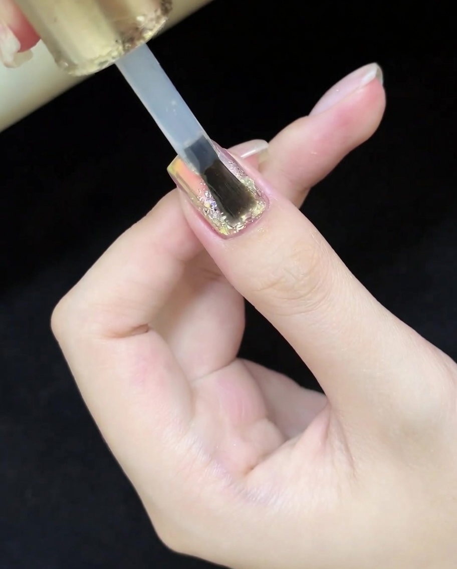 完成したデザイン全体に最後のトップコートを塗っている様子。