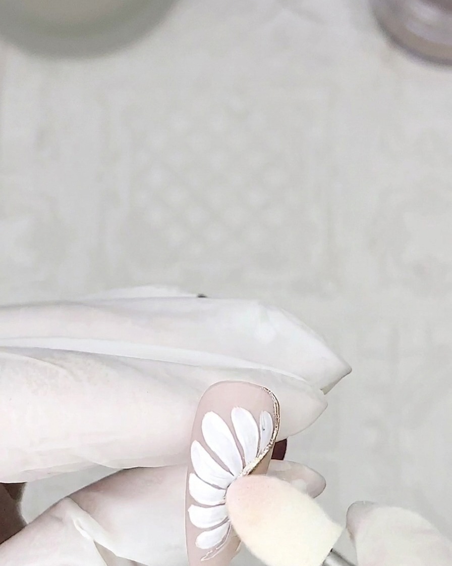スポンジチップでクロームパウダーを花びらの縁に擦り付けている様子。