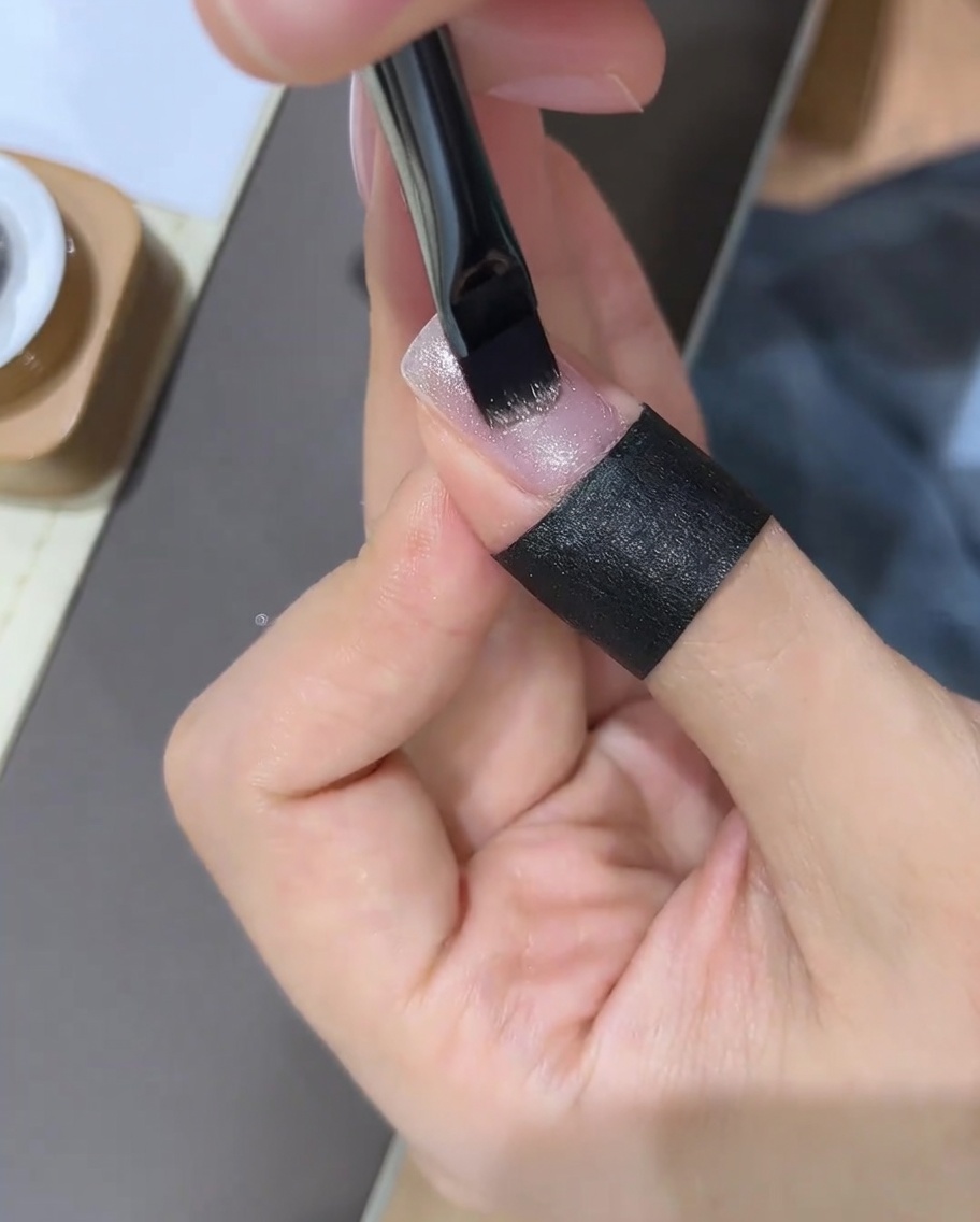 塗ったばかりのジェルにマグネットをかざして模様を作っている様子。