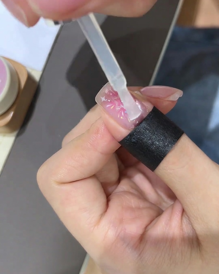仕上げのトップコートを塗っている様子。