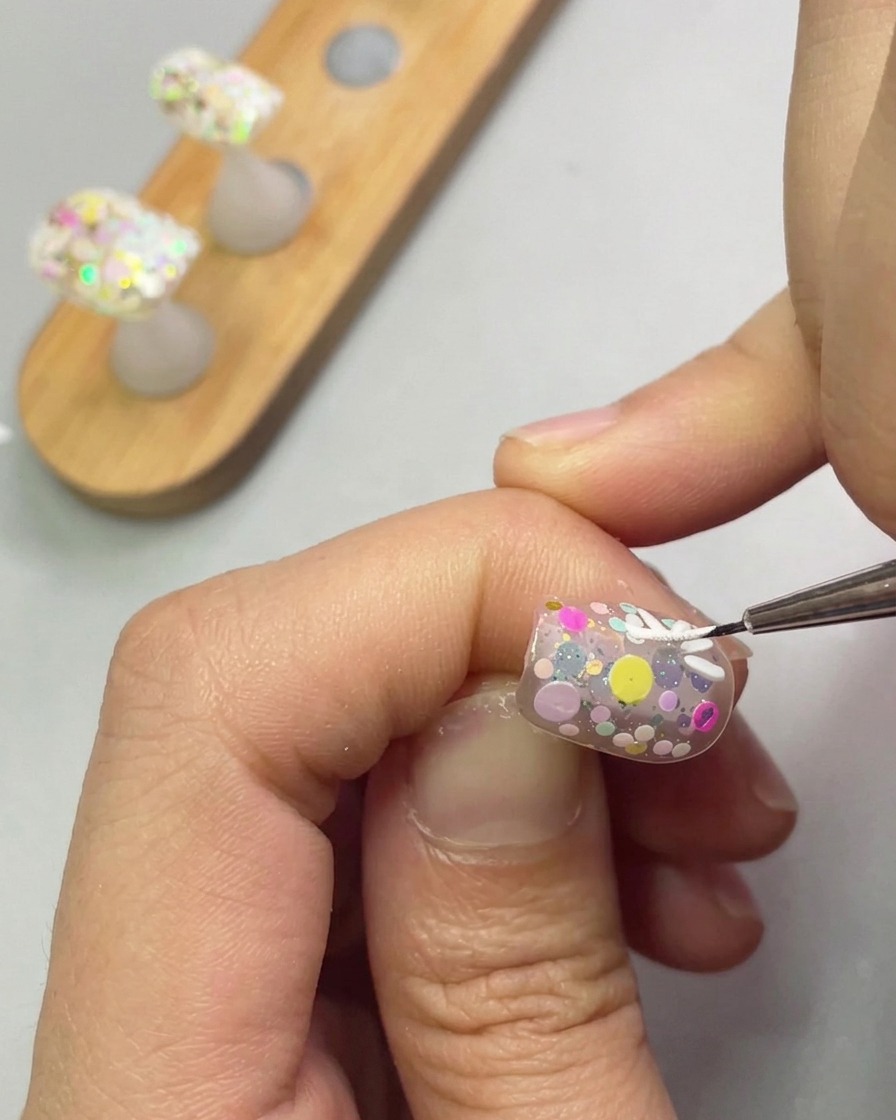 細筆を使ってデイジーの花びらを付け足し、花を完成させている様子。