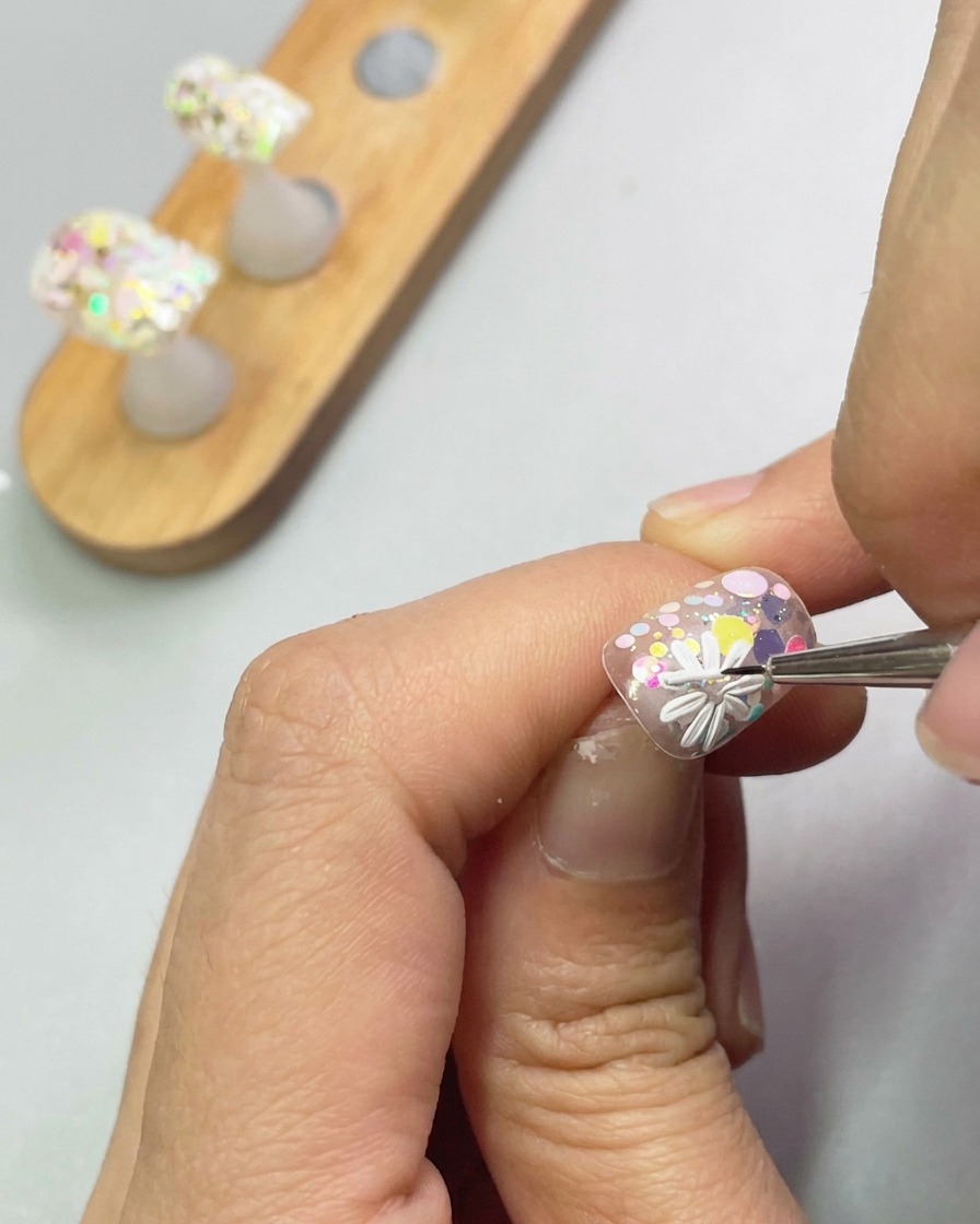 3Dジェルを使って、1つ目の花の隣に2つ目の小さなデイジーを形成している様子。
