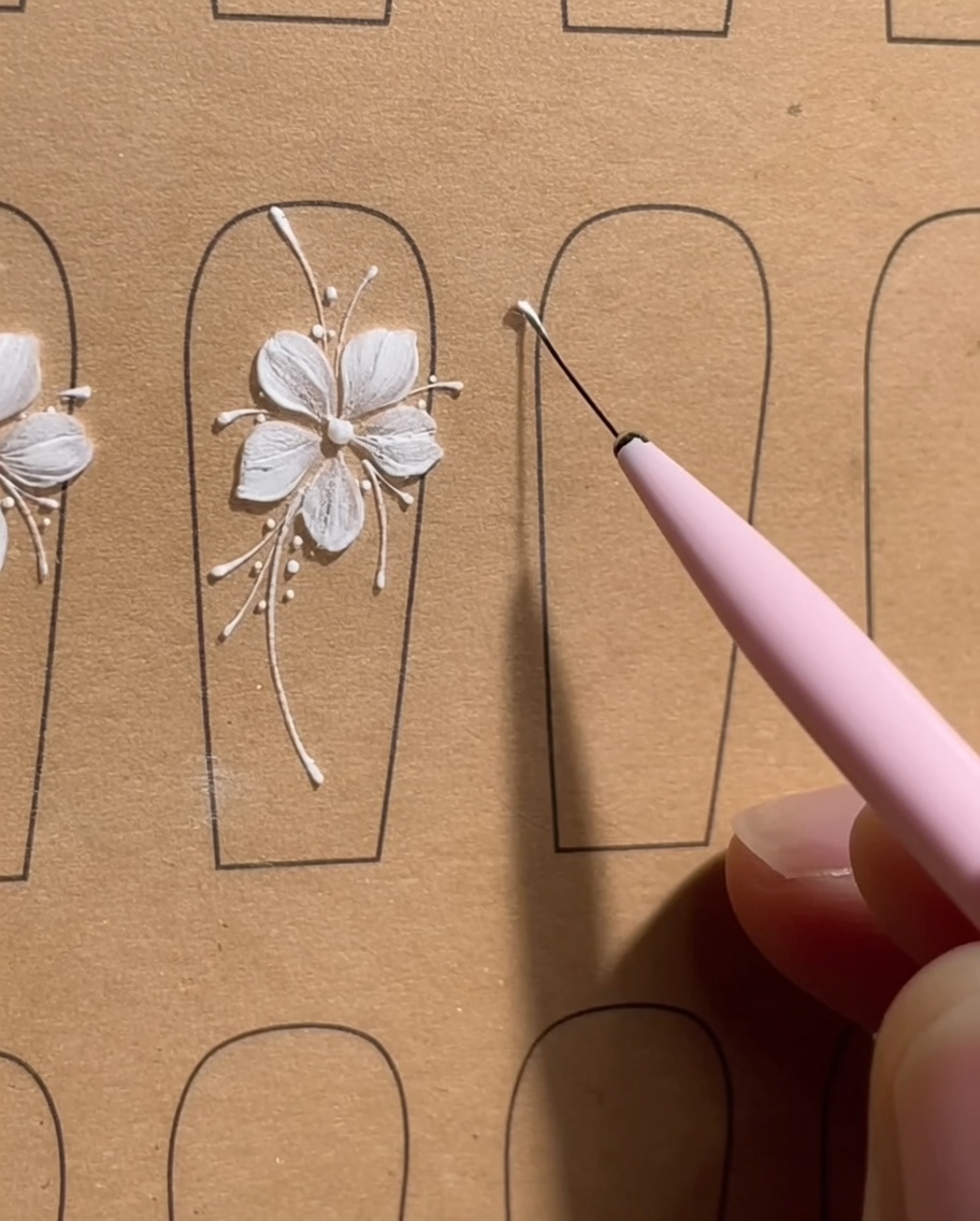 爪に白いジェルの小さなドットを円状に5つ配置し、花びらのガイドラインを描いた状態。
