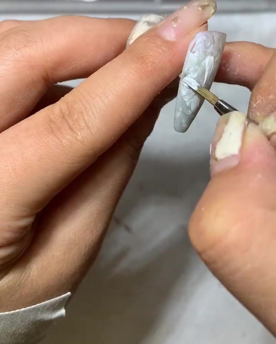 ライナーブラシの先を使って、花びらの端を細く整えている様子