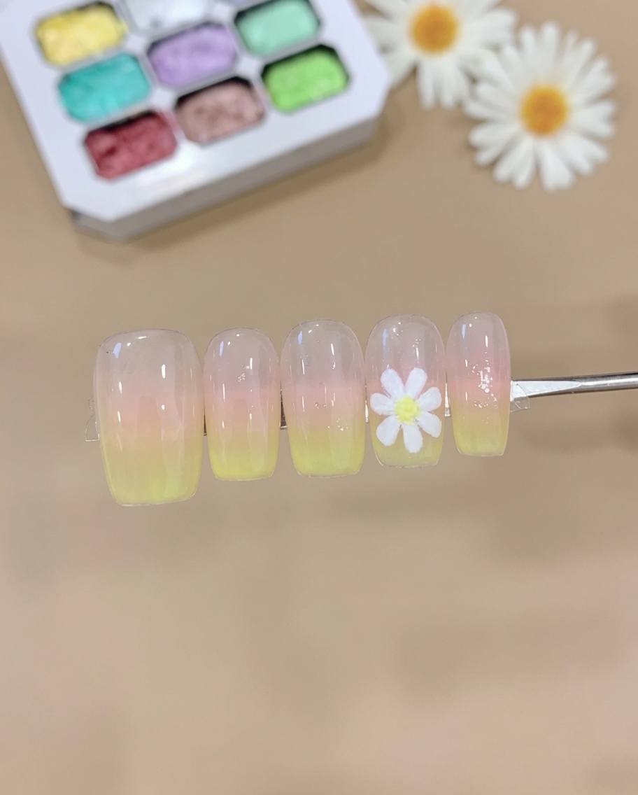 メイク用スポンジにピンクとイエローのジェルを取り、爪先でポンポンと叩いてオンブレグラデーションを作っている様子。