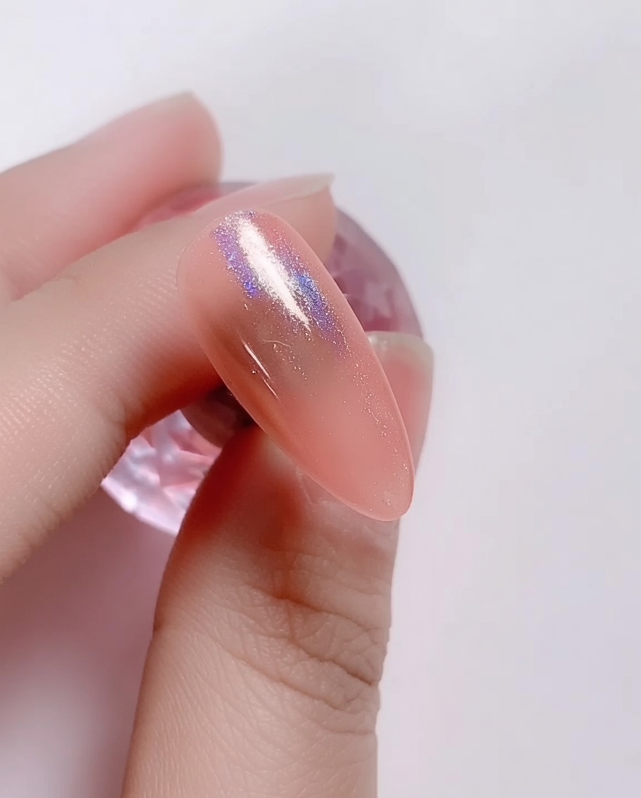 スポンジチップで虹色のレーザーパウダーを爪にこすりつけている様子。