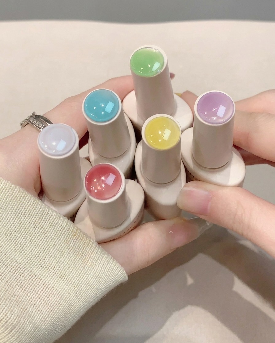 アートを施したネイル全体に、クリアのトップコートを塗っている様子。