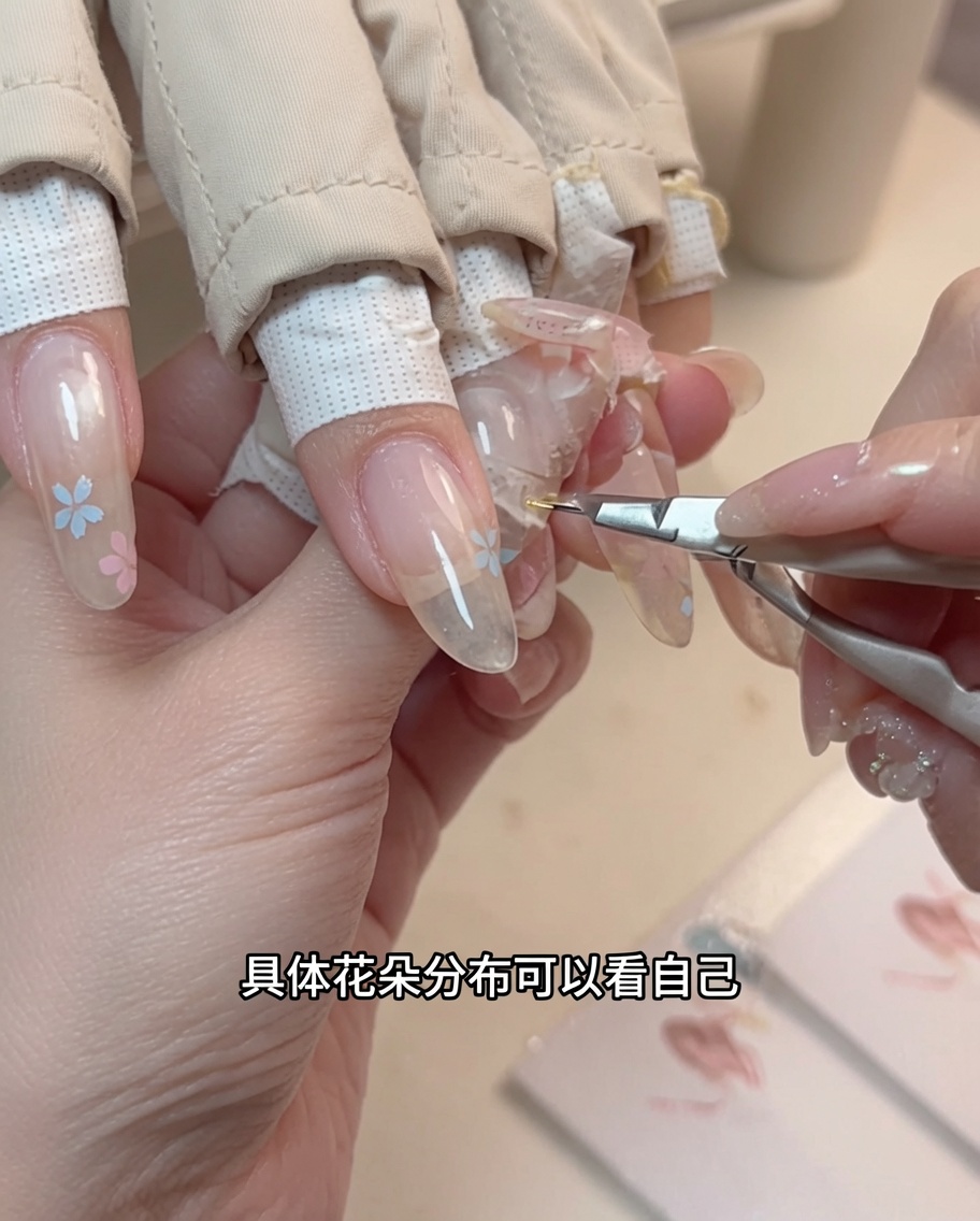 ドッティングツールを使用して、爪の上に描かれた花の中央に小さな黄色の点を配置しているクローズアップ。