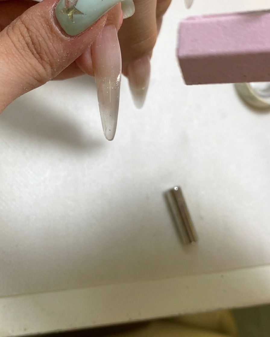 携帯用UVライトでマグネットネイルを硬化させている様子。