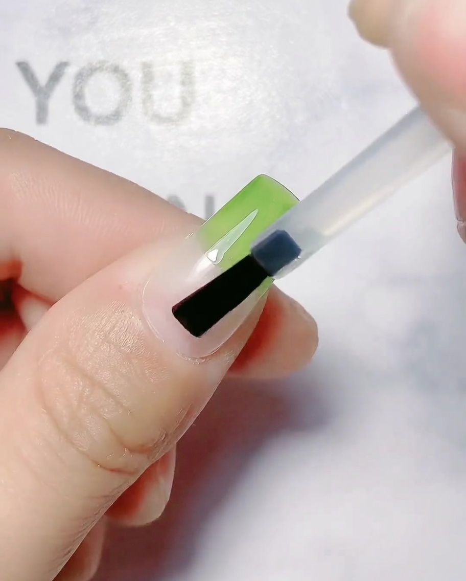 自爪の上半分にオリーブグリーンのジェルを塗布している様子。