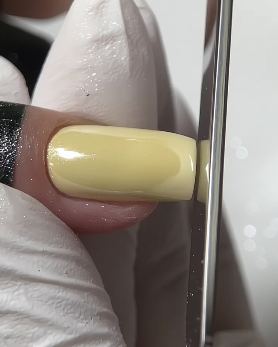 スクエアのクロムネイルのエッジをネイルファイルで整えている画像。