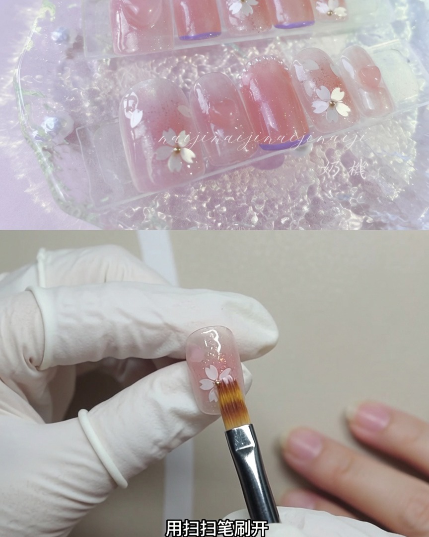 装飾された爪の上を軽く掃いてきらめく粒子をぼかしている、ソフトなダストブラシを持っている手袋をした手。