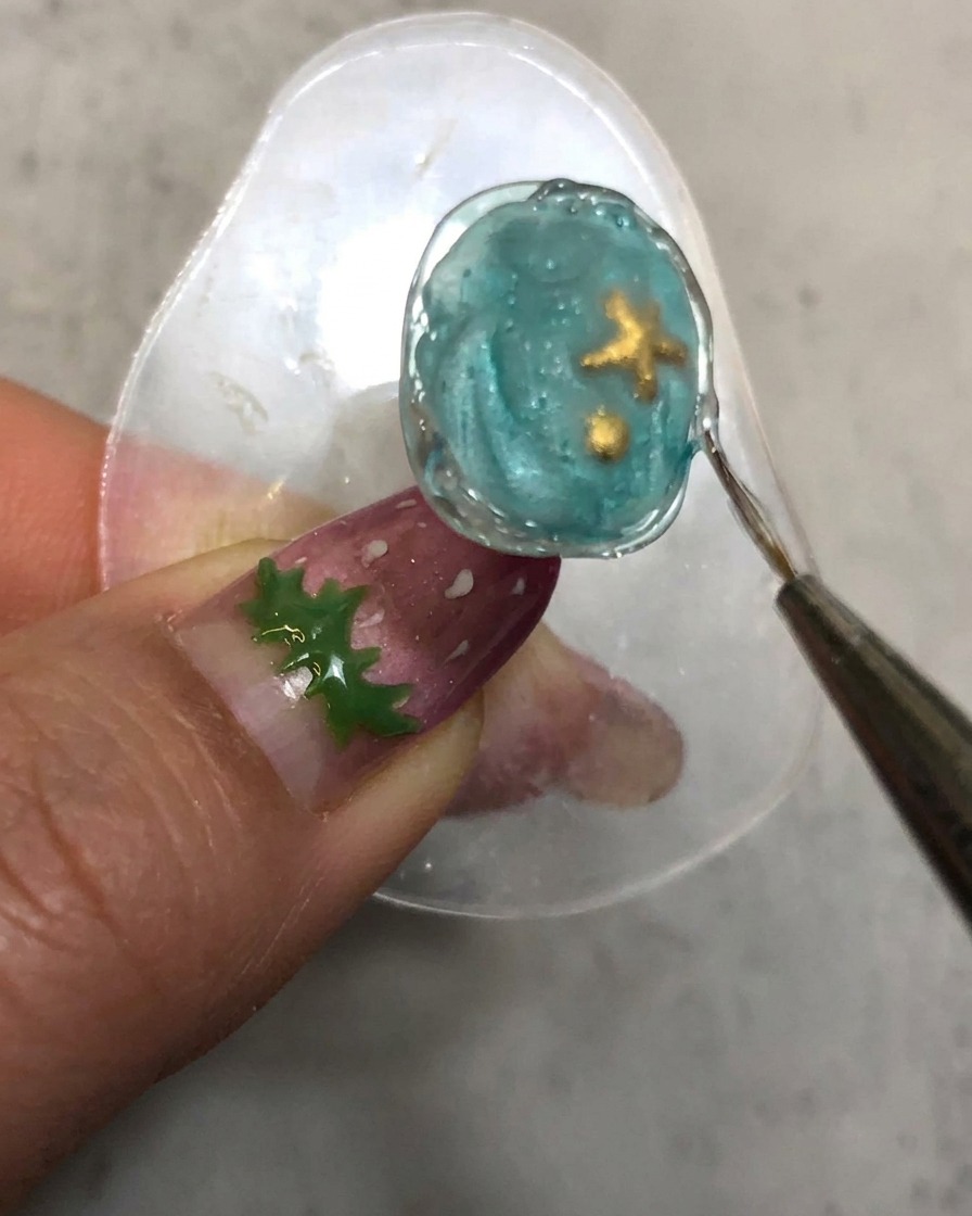 硬化させた凹凸のある縁取りラインに沿って筆を動かす様子。