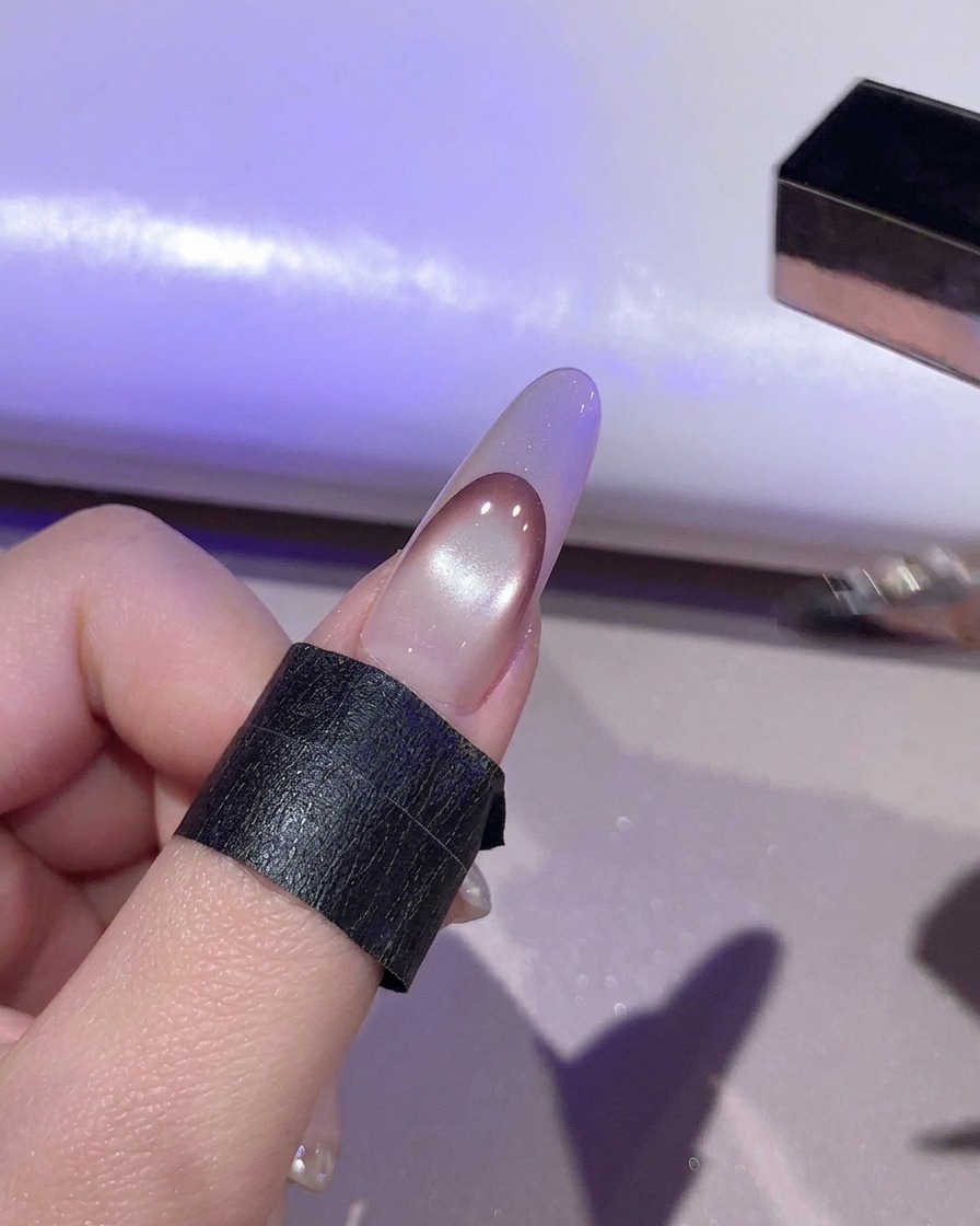 UV/LEDランプの中で、紫色の光の下で硬化している爪。