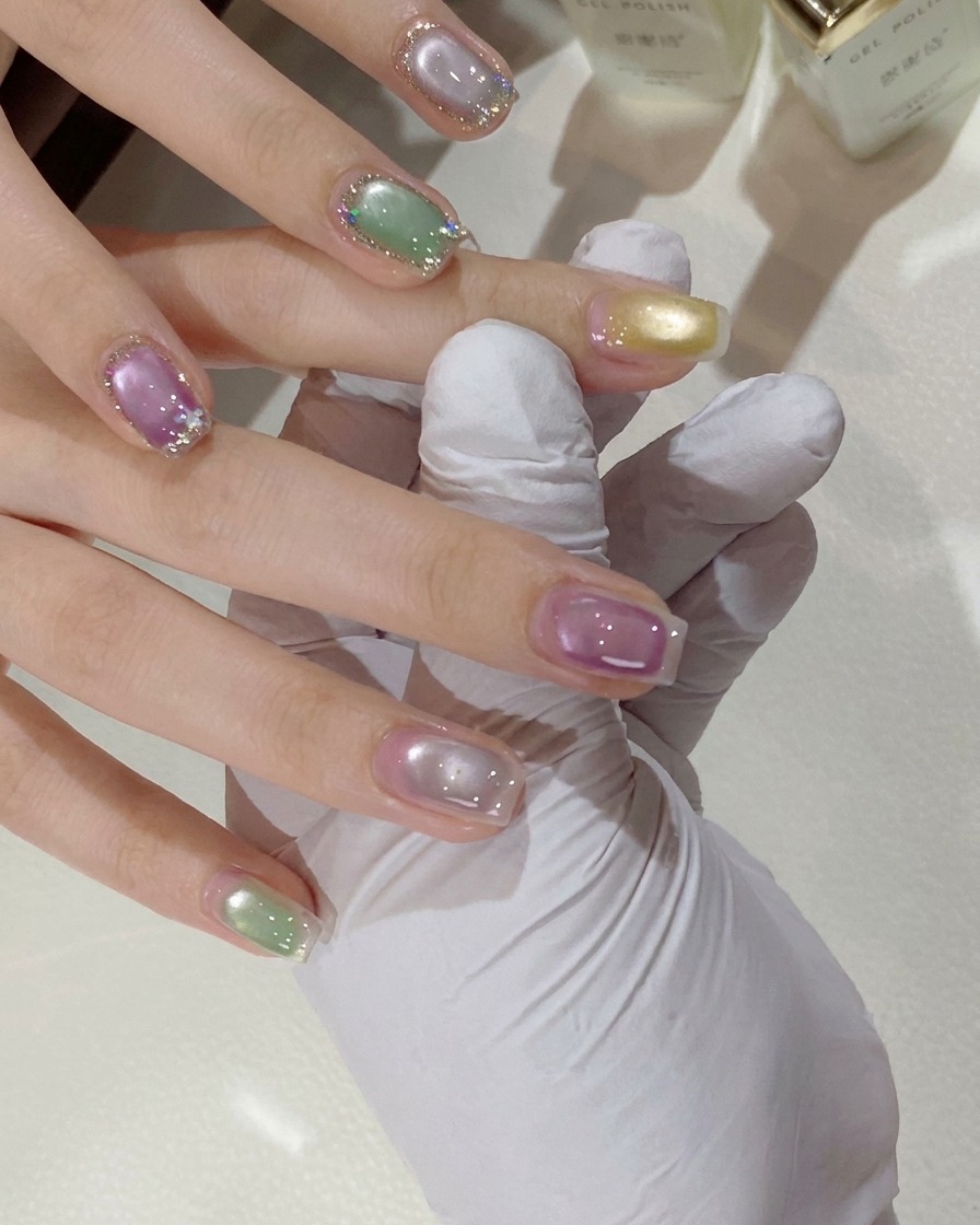 硬化のためにミニピンクのUV/LEDランプの下に配置された手。