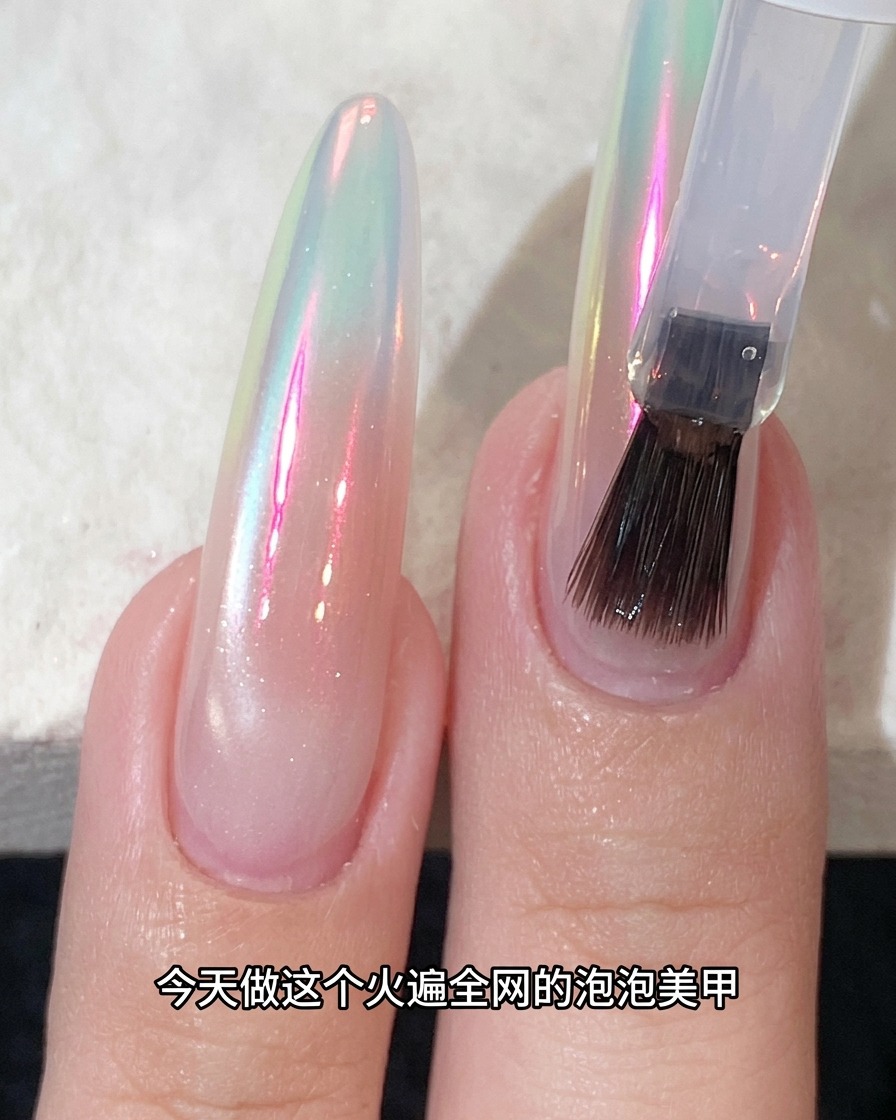 オーロラパウダーで仕上げた輝く爪の上にトップコートを塗布している様子。