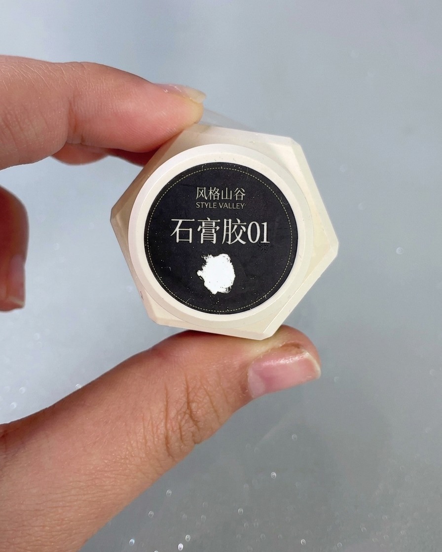 ネイル上でプラスジェルを使用して盛り上がった白いウェーブパターンを細かく描いている極細ネイルアートブラシ。