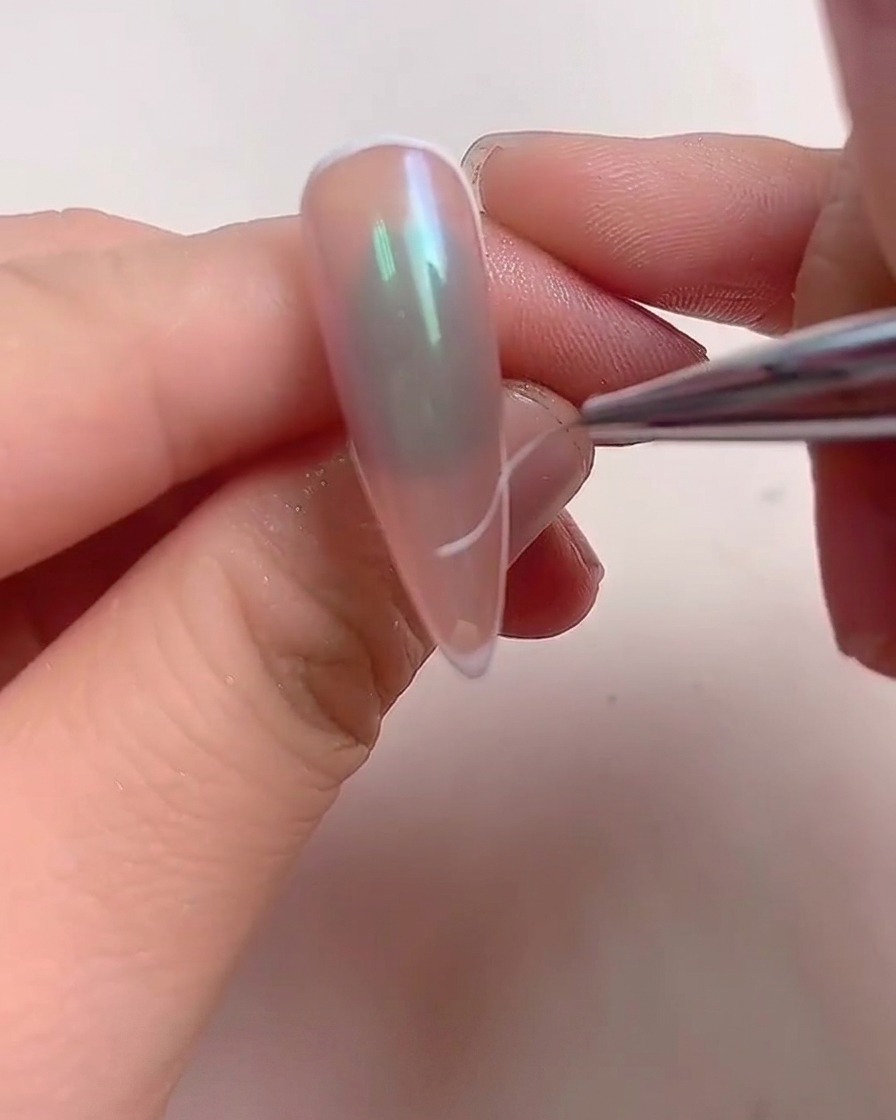 指を照らす光る紫色の光を備えたプロ用のUV/LEDネイルランプの中に置かれた手。