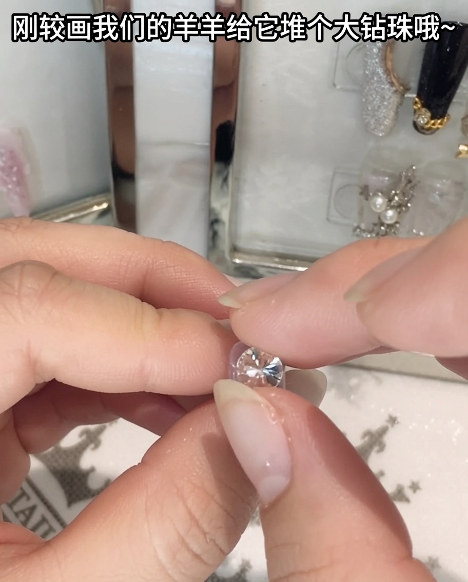 先のとがったピンセットで大粒のクリスタルラインストーンをつまみ、位置を合わせている様子。