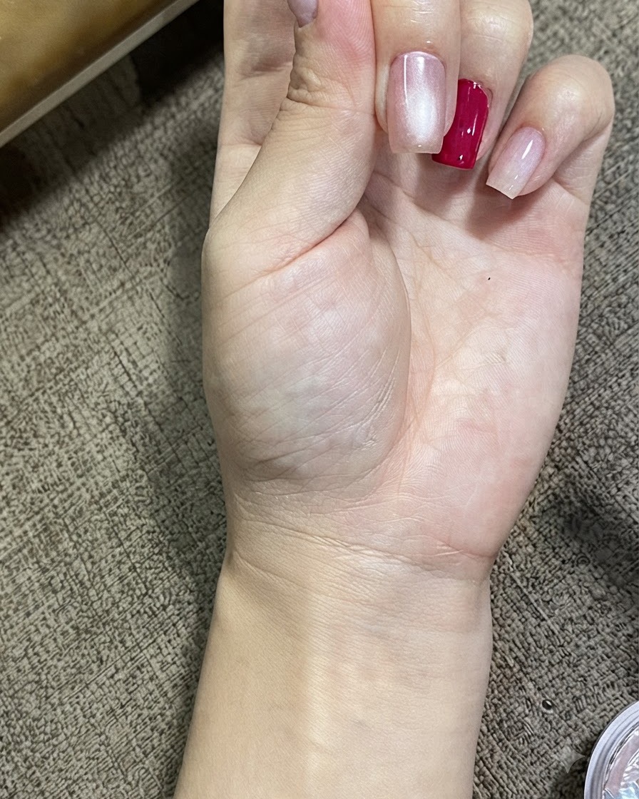 マグネットキャッツアイジェルを塗った爪に、光り輝く球体の効果が現れている手のアップ画像。