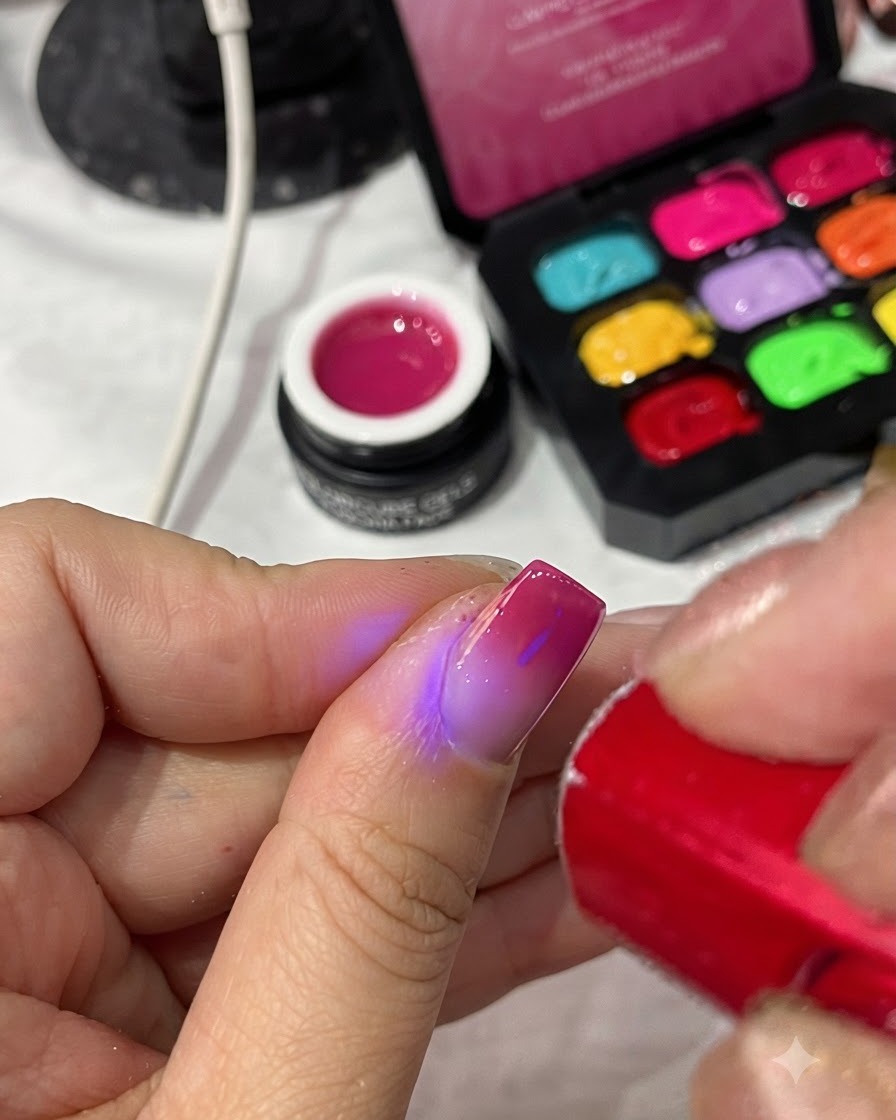 ポータブルな赤いUV/LEDランプが、完成したマニキュアのトップコートを硬化させているところ。
