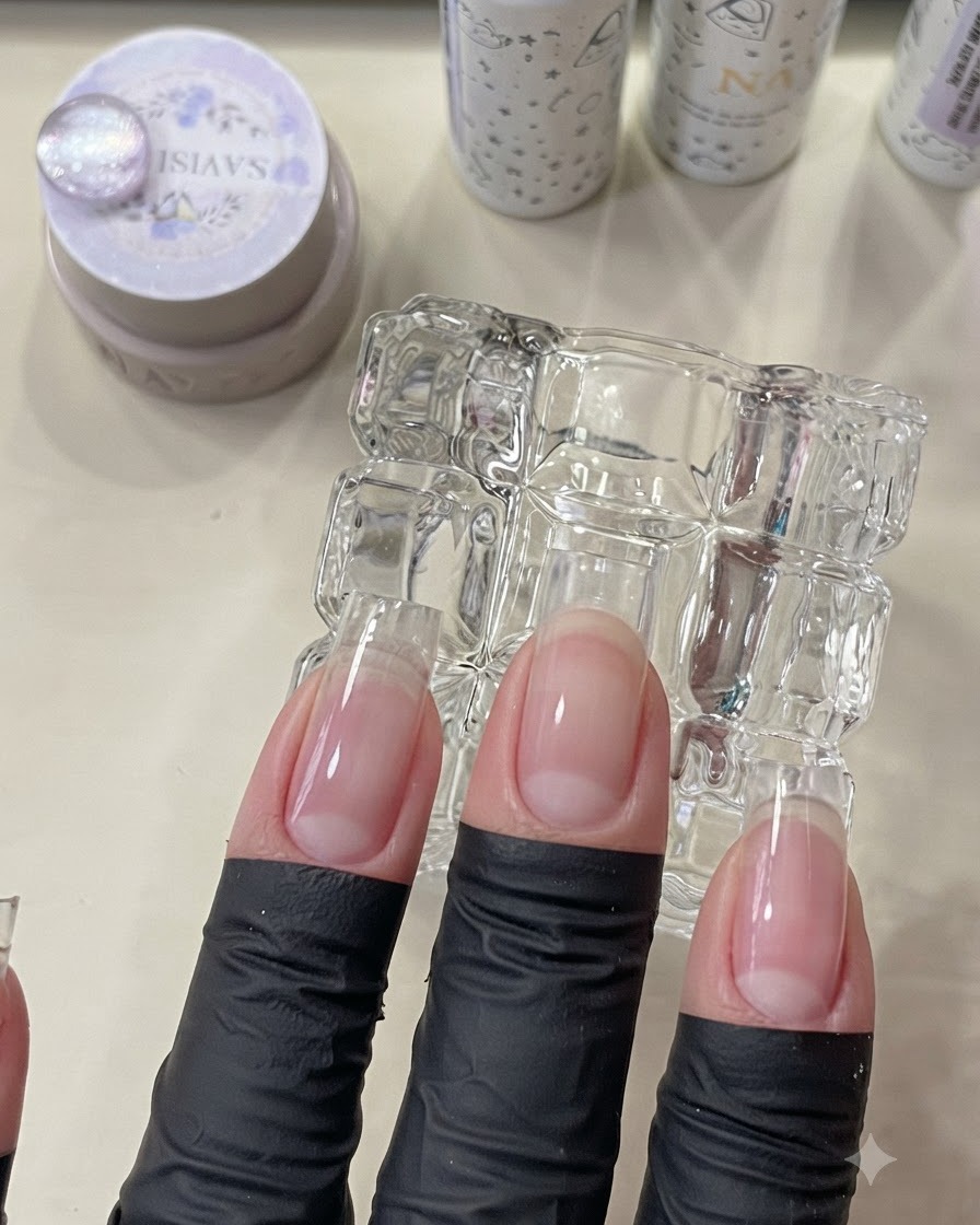 ベースコート層を硬化させるために、UV/LEDミニランプの下に配置された指。
