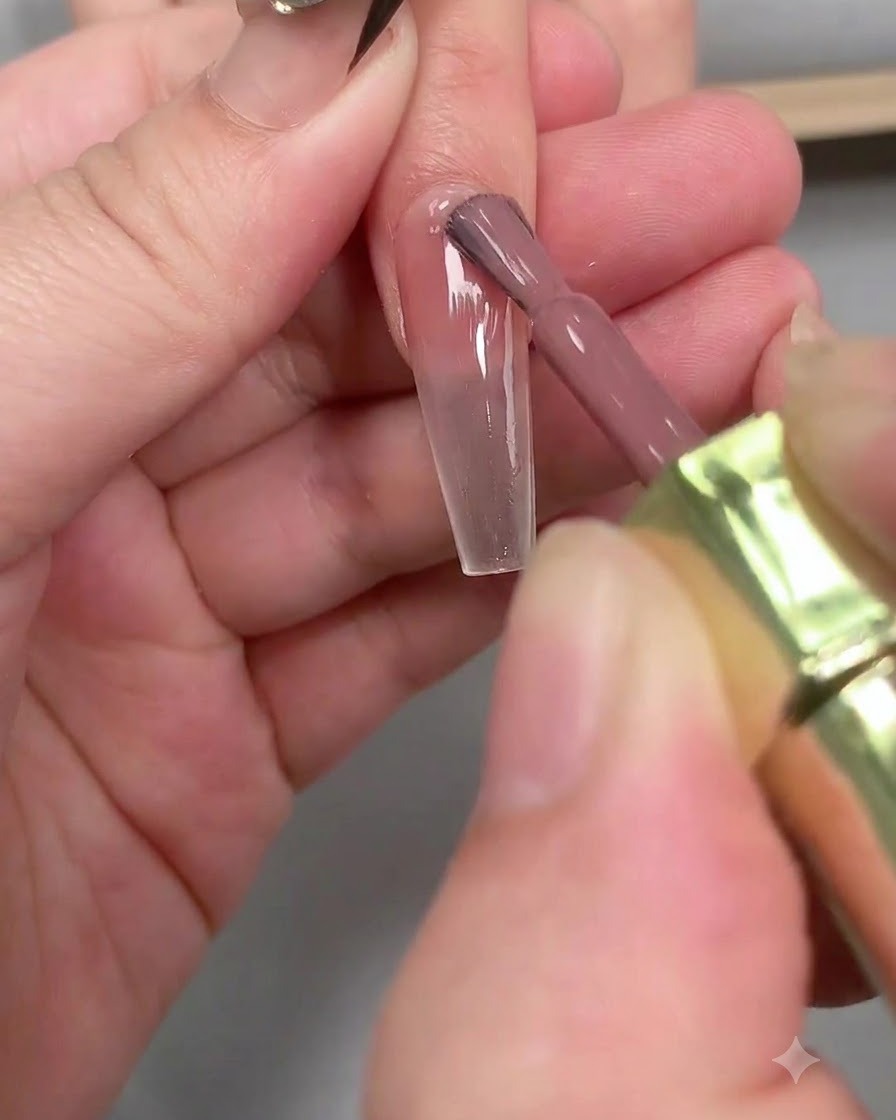 ピンセットを使って、長いコフィン型の爪から白いフレンチガイドテープを慎重に剥がしている様子。