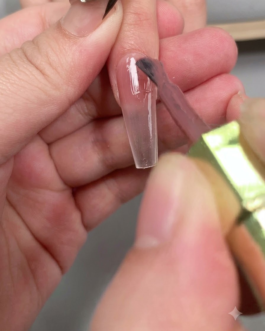 爪全体にツヤのあるダイヤモンドトップコートを筆で塗っている様子。