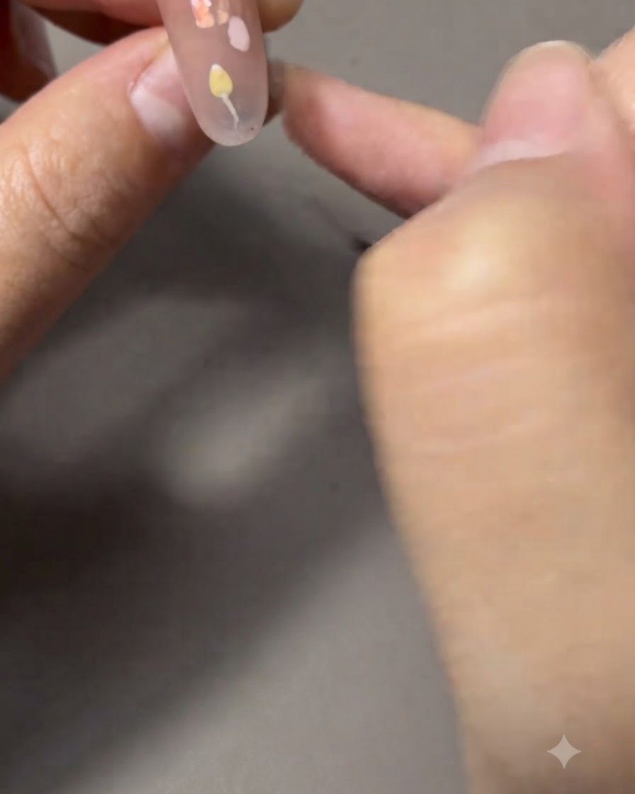 チューリップにつながる細い緑色の茎と葉を極細ライナーブラシで描いている様子。