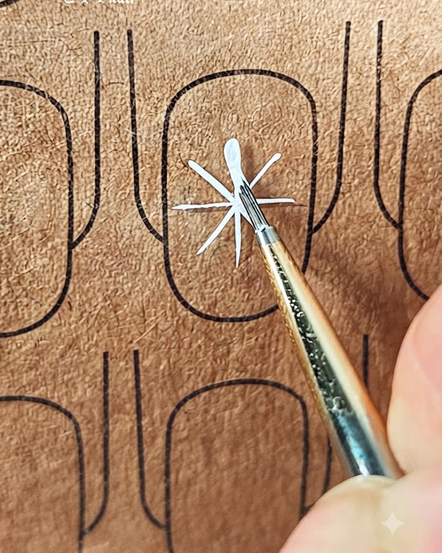 ガイドラインの中央から外側に向かって白い花びらの最初のストロークを作っている細い筆。