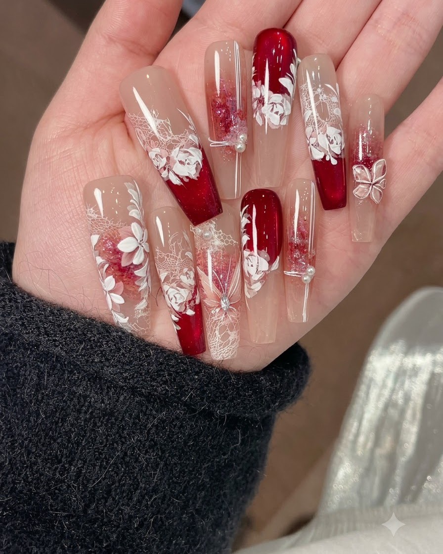 細いブラシがネイルデザイン上で緑と赤を混ぜた水彩ピグメントを使用して葉を描いている様子。