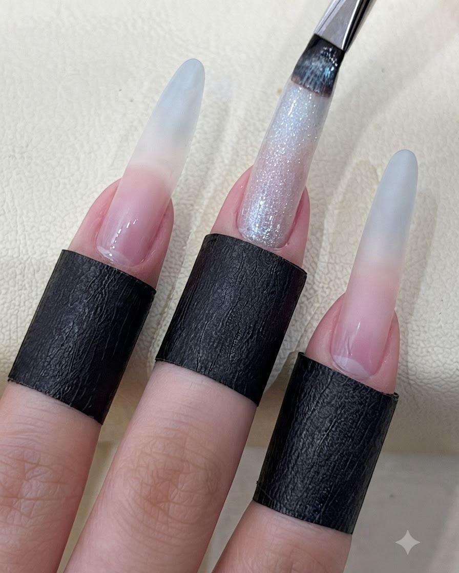 ネイルブラシを使って、長く成形された爪にキラキラとしたスターリーキャッツアイジェルを塗布している様子。