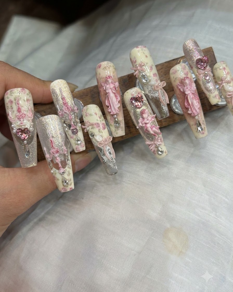 ピンセットを使って、仕上げの爪に3Dリボンのパーツやラインストーンを置いている様子。