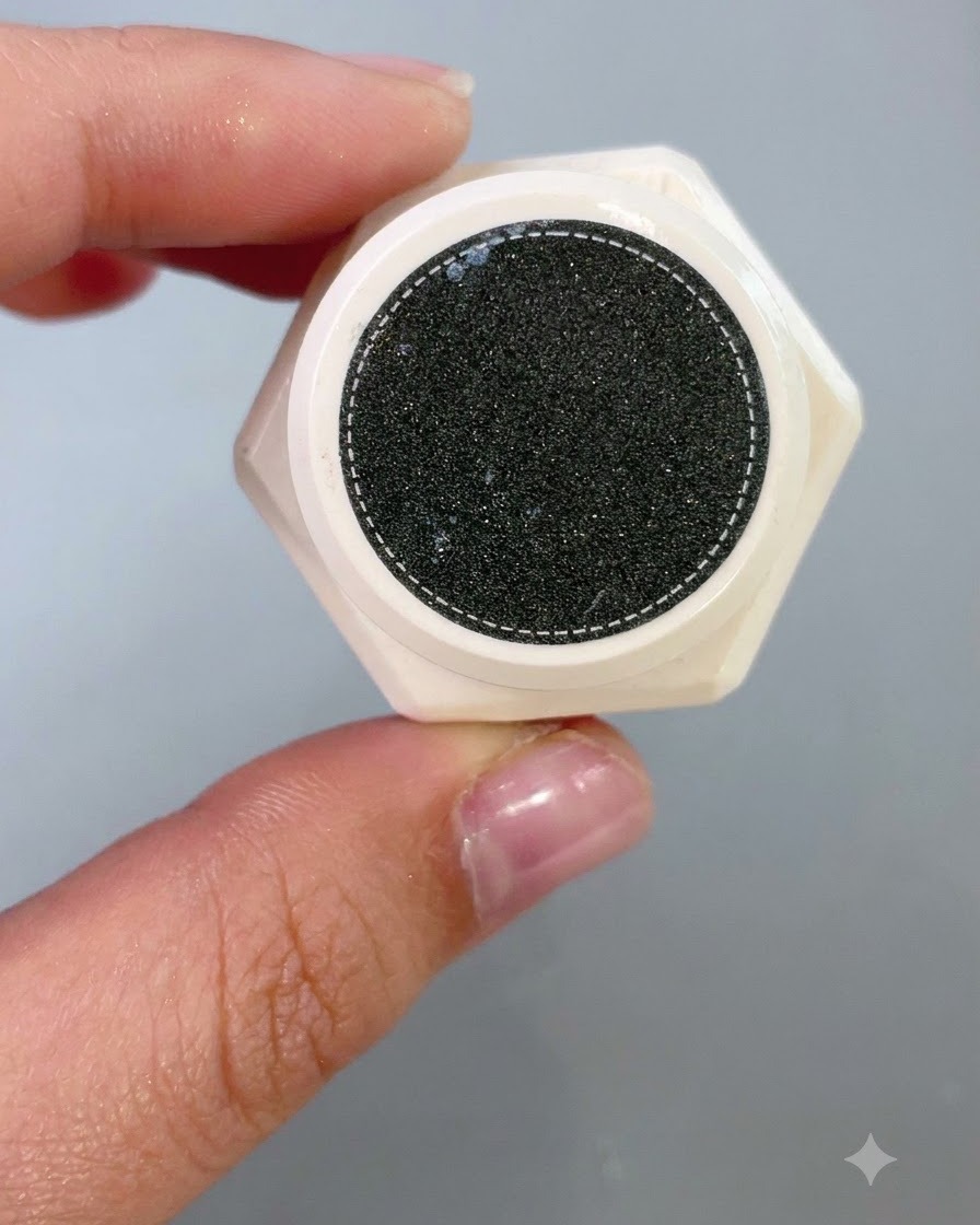 まだらの暗い表面を持つ、テクスチャー造形製品の開いたジャーの中を上から見下ろしたクローズアップ。