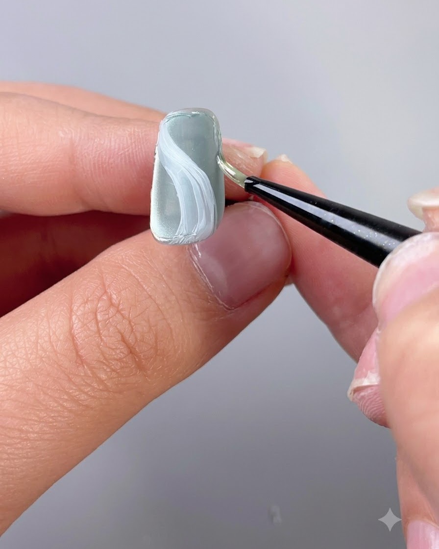 細かいディテールブラシを使い、テクスチャー造形ジェルでネイルのエッジに沿ってアウトラインを描いているところ。