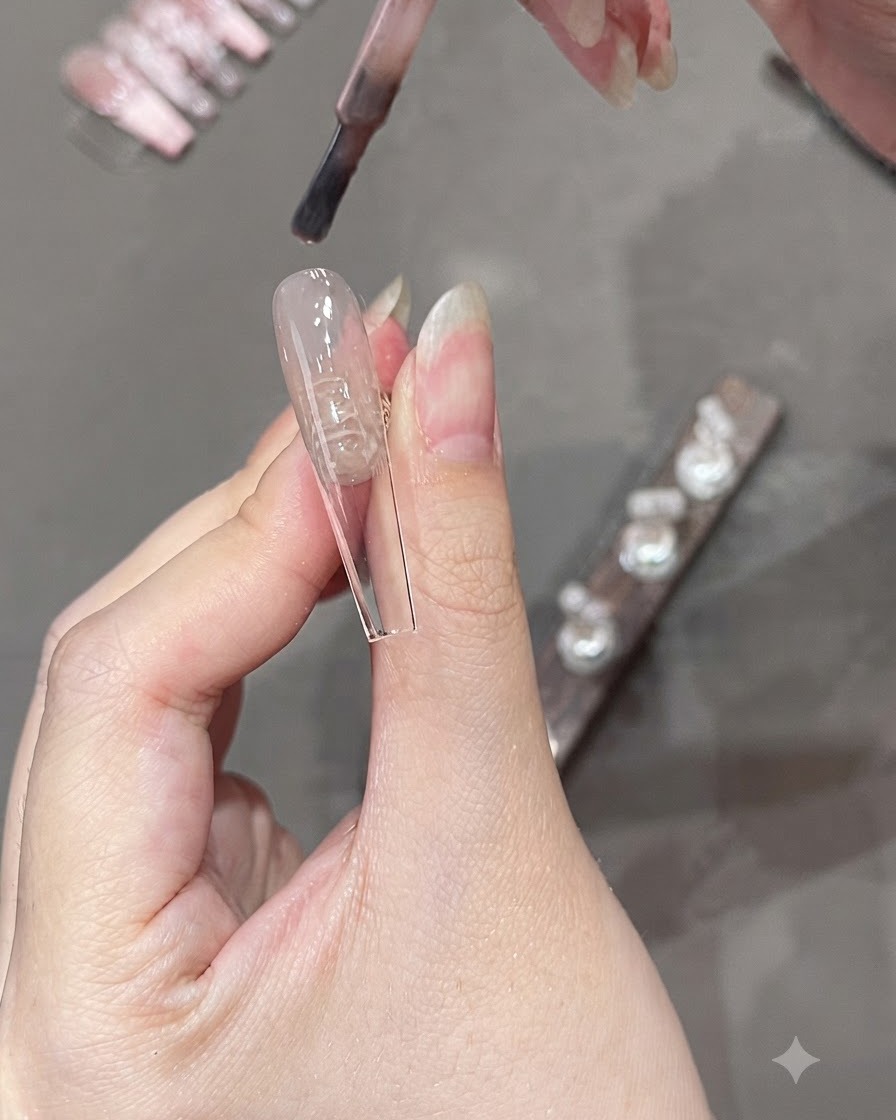 ネイルチップの下半分に半透明のピンクカラーを塗るジェルブラシ。