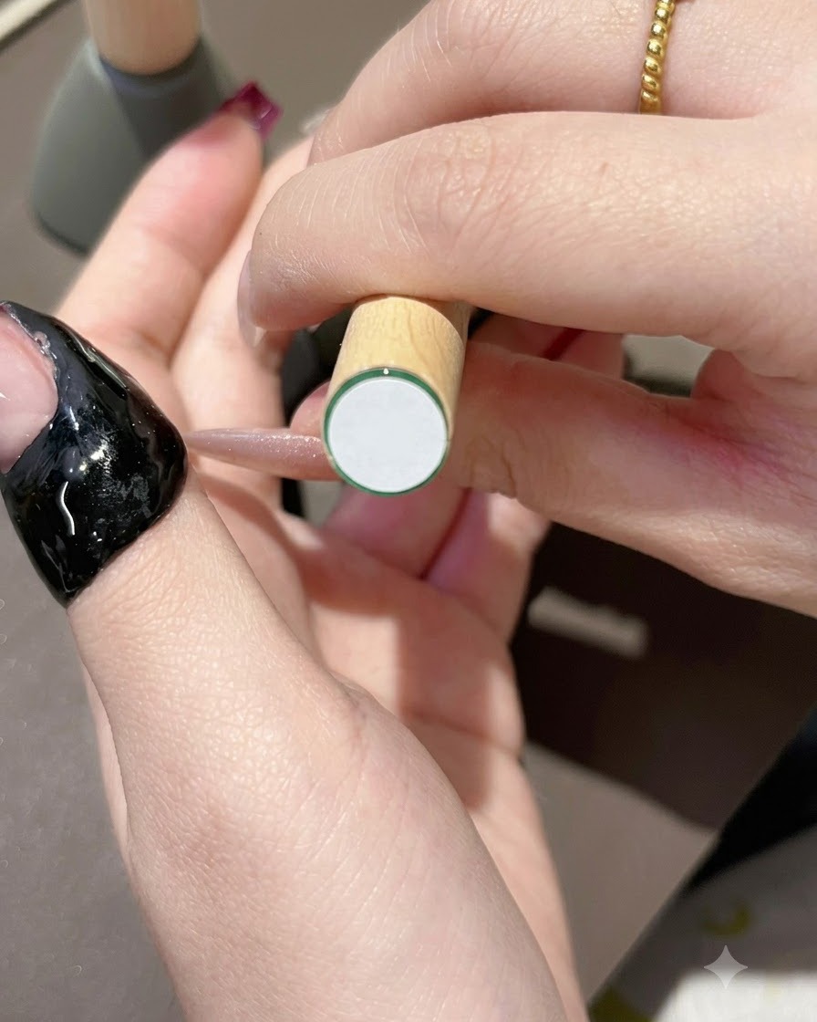 ナチュラルな爪の先端にダークパープルのジェルポリッシュをブラシで塗布している様子。