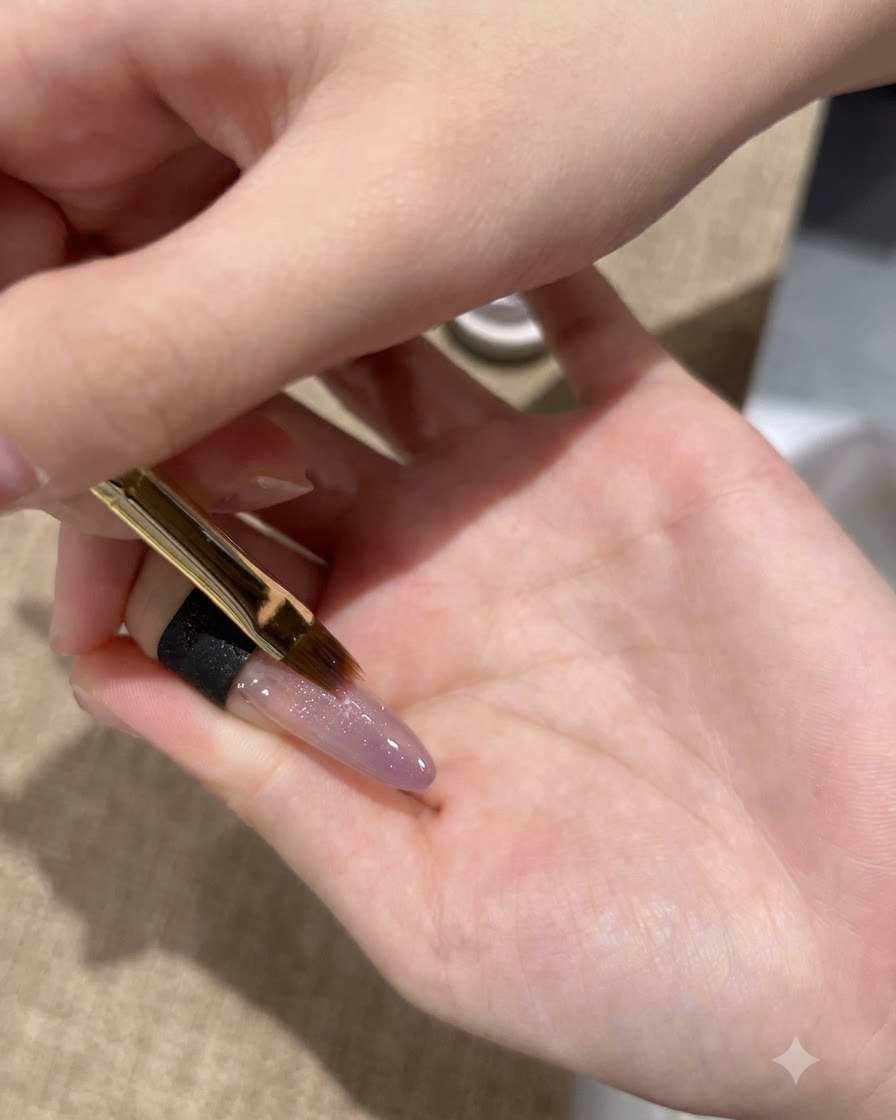 細いブラシを使って、爪の先端にパープルキャッツアイジェルの2層目を塗る様子。