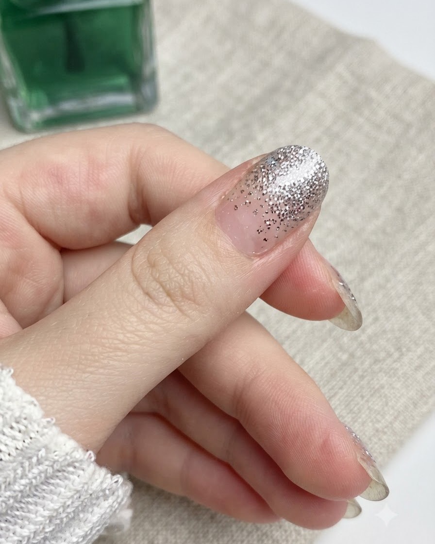 親指の爪の端に沿って、ネイルファイルが下向きに動いている様子。